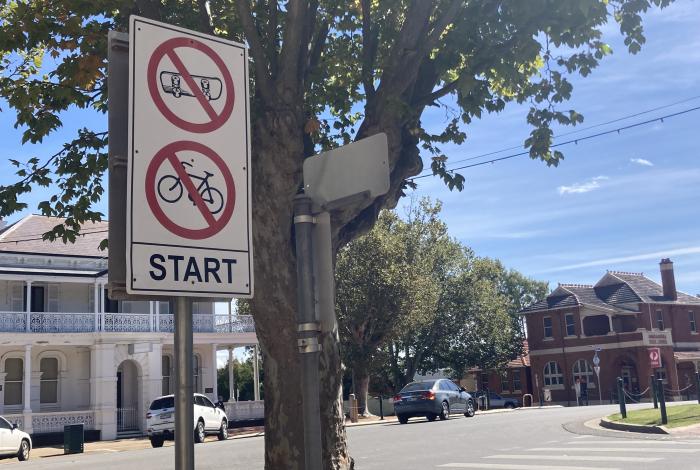 A no scooter and no bicycle sign on a street