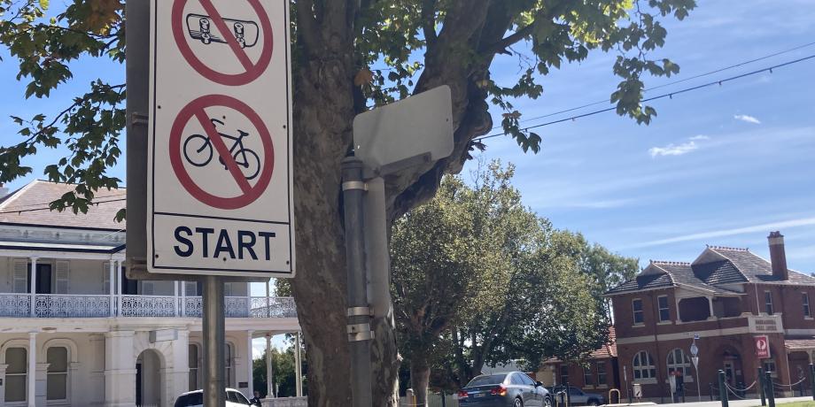 A no scooter and no bicycle sign on a street