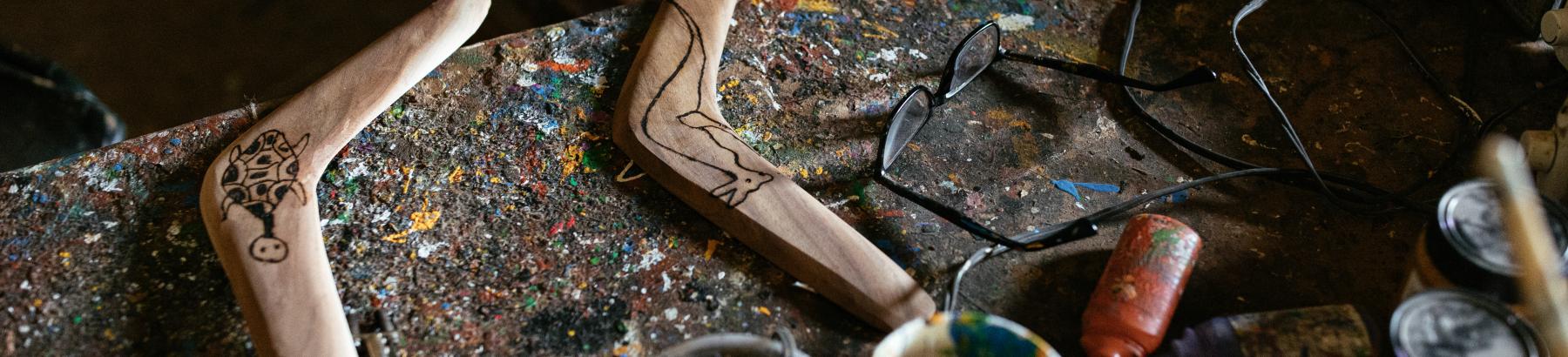 Two boomerangs on a workbench at Sandhills Artefacts in Narrandera NSW