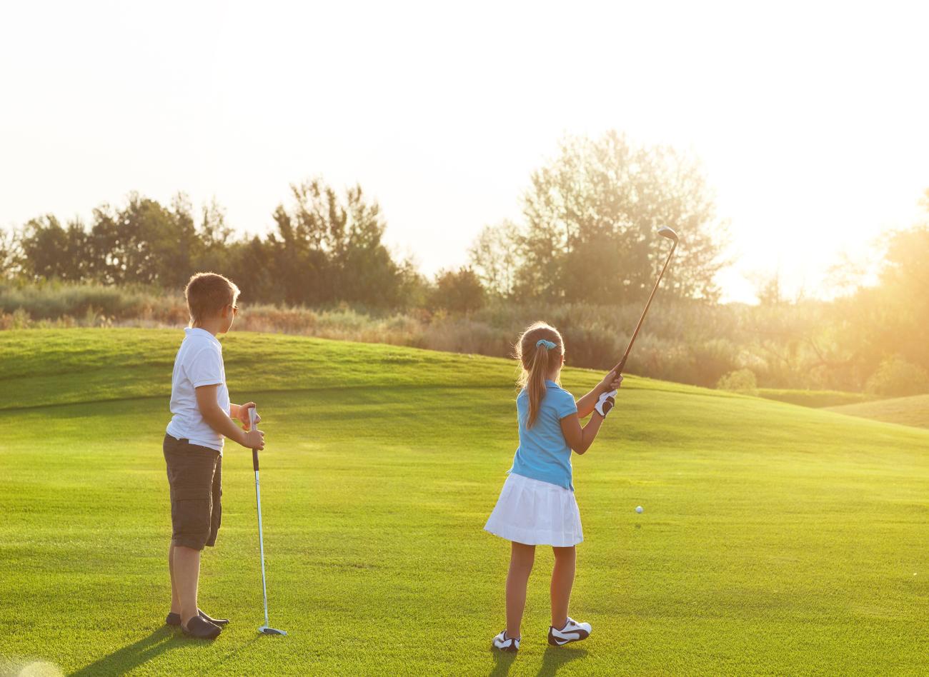 Two children playing golf