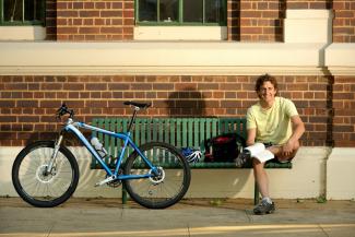 Cyclist reading outside Council Chambers