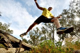 Man leaping over logs 
