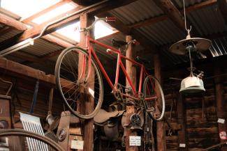 Red bike suspended inside shed at the Parkside Cottage Museum, Narrandera.